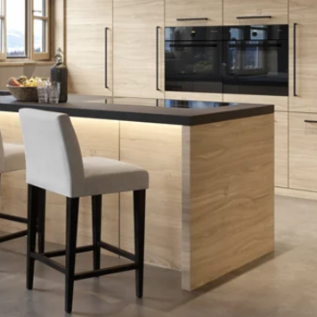 Modern kitchen with wooden cabinets and black countertops.