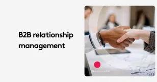 Two people shaking hands in a business meeting, representing B2B relationship management.