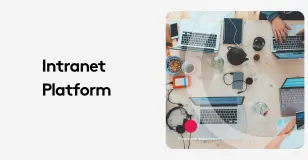 Top view of a work desk with laptops, phones, and office supplies for intranet platform.