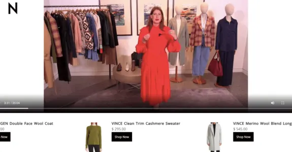 Woman in red dress presenting fashion showroom with clothing rack and mannequins.