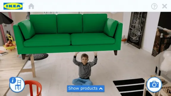 Child holding a green sofa in an IKEA showroom with product display options.