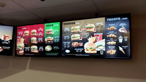 Fast food restaurant menu display featuring burgers, chicken, and sides.