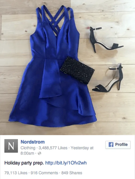 Blue party dress with black heels and clutch on wooden floor.