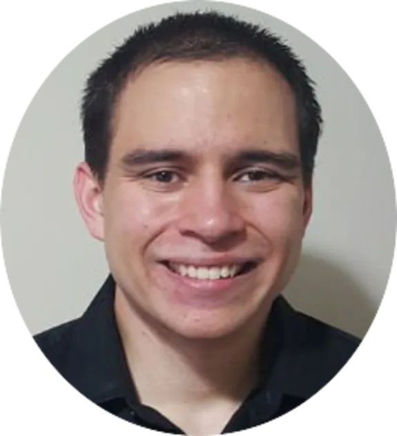 Smiling man in a black shirt against a plain background.