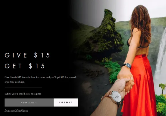 Couple holding hands near waterfall promoting give $15 get $15 offer.