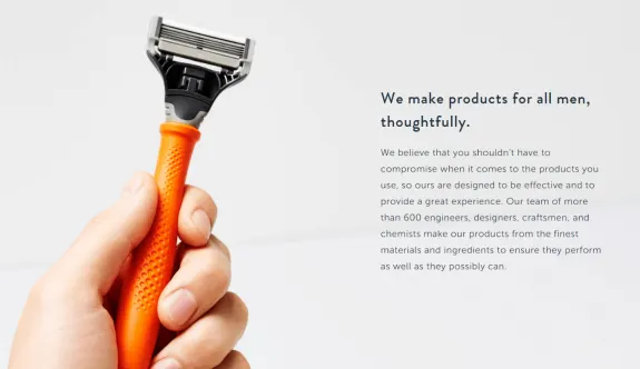 Hand holding an orange razor with text about thoughtful men's products.