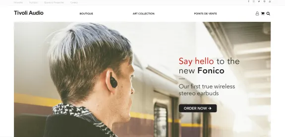 Man wearing wireless earbuds standing at a train station