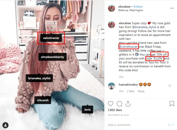 Woman taking a selfie in a cozy room with fashion brand tags visible.