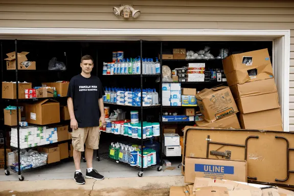 Man standing in garage with storage shelves and boxes