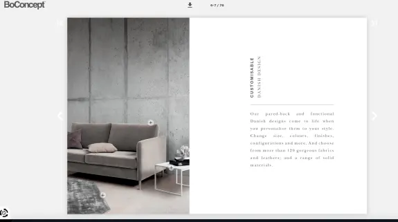 Modern gray sofa in a minimalist living room with concrete wall and small table.