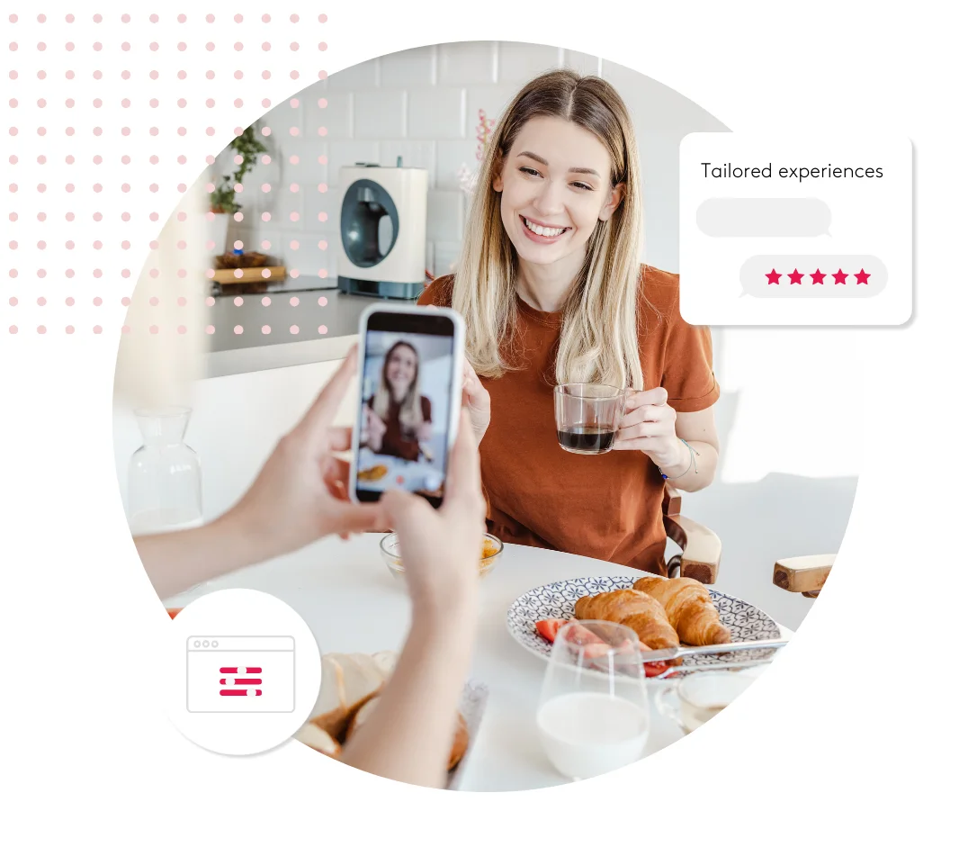 Woman smiling at breakfast table while someone takes a photo with a smartphone.