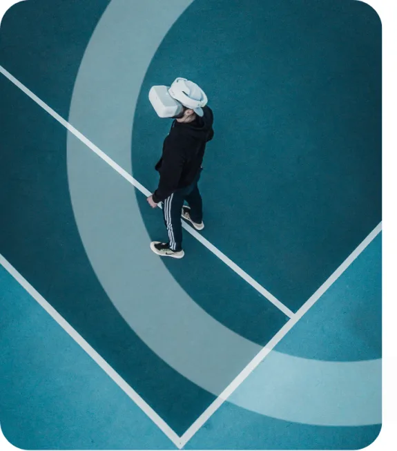 Person wearing a VR headset standing on a blue geometric background.