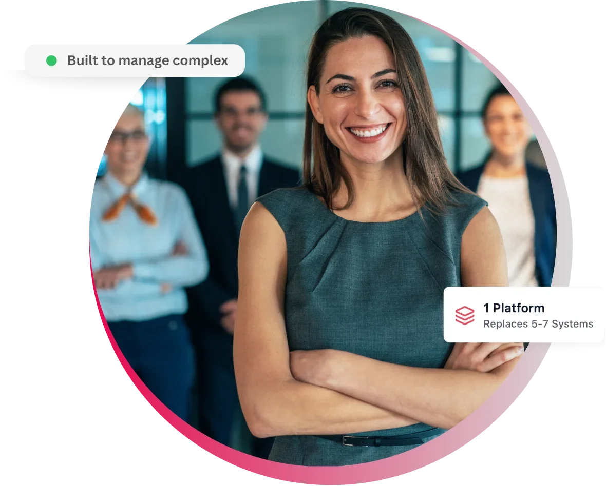 Smiling woman in business attire stands confidently with team in background.