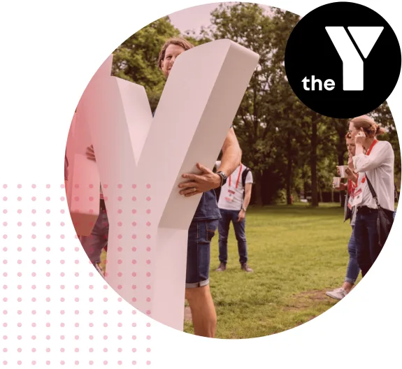 Group of people holding a large letter Y outdoors in a park setting.