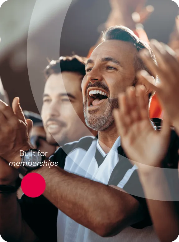 Cheering sports fans in a stadium with a focus on a middle-aged man.