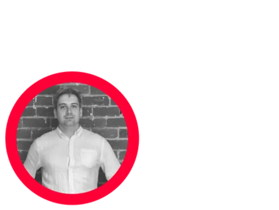 Man in white shirt standing against a brick wall with a red circle overlay.